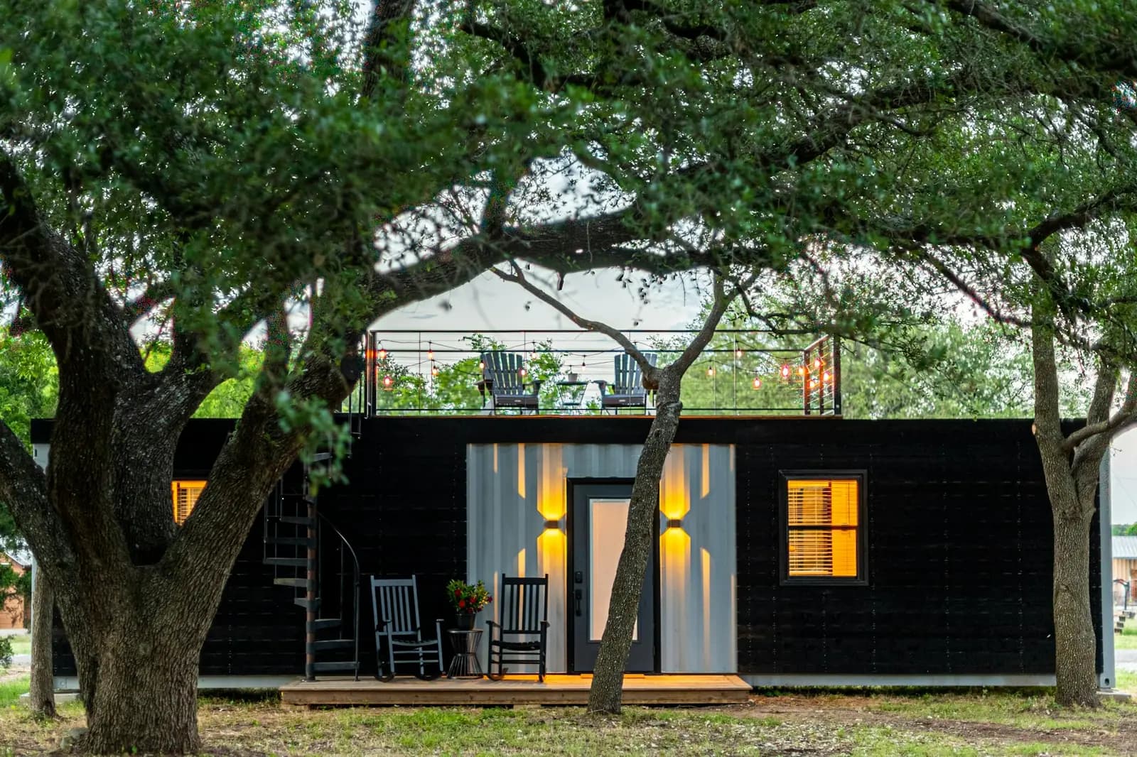 Casa hecha con contenedores, con galería, luces cálidas y terraza en la azotea